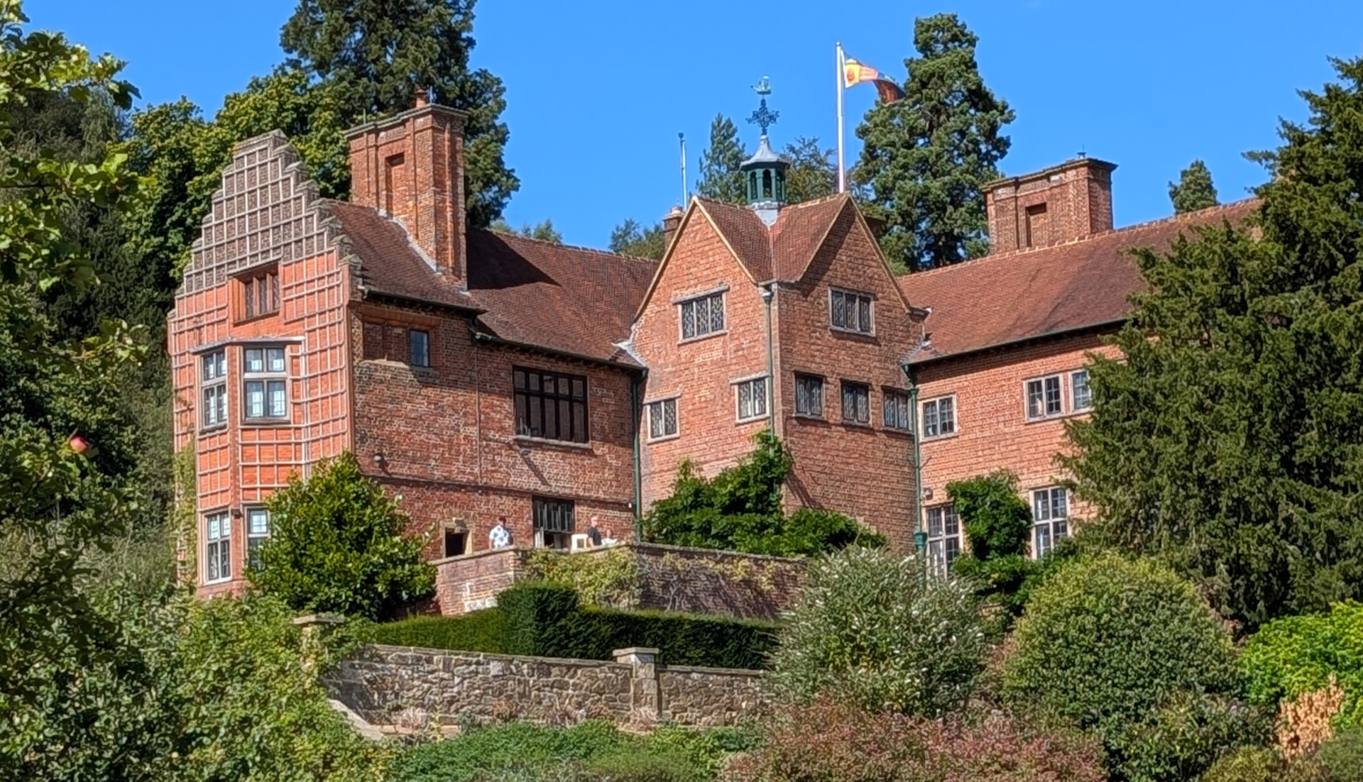 Chartwell, Churchill's red-brick house seen from its terraced gardens under a blue sky